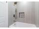 Elegant bathroom showcases a sleek white tub and luxurious shower with neutral toned tiling at 1011 W Weldon Ave, Phoenix, AZ 85013