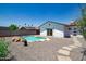 Backyard featuring an in-ground kidney shaped pool with rock feature and white modern style house at 1011 W Weldon Ave, Phoenix, AZ 85013