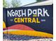 A community sign in black, white, yellow, and red with the words 
