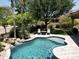 Tranquil pool area featuring a rock waterfall, lush greenery, and a cozy seating area with a fire pit at 1092 N Roosevelt Ave, Chandler, AZ 85226