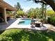 Inviting backyard pool and fire pit, surrounded by tropical landscaping, creates a resort-style atmosphere at 1092 N Roosevelt Ave, Chandler, AZ 85226