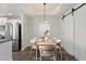 Staged dining room showcasing modern finishes, decorative lighting and a view of the kitchen at 11762 E Becker Ln, Scottsdale, AZ 85259