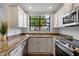 Bright kitchen showcasing granite countertops, white cabinetry, and a large window with natural light at 11762 E Becker Ln, Scottsdale, AZ 85259