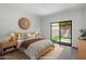Staged bedroom with wood-look floors, a decorative headboard, and a sliding glass door to the backyard at 11762 E Becker Ln, Scottsdale, AZ 85259