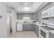 Cozy kitchen features grey cabinets, white appliances and backsplash, and tile floor at 13408 N 25Th Dr, Phoenix, AZ 85029