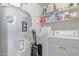 Functional laundry room with washer, dryer, shelving, and hot water heater at 13408 N 25Th Dr, Phoenix, AZ 85029