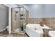 Bathroom featuring glass enclosed shower, soaking tub, and tile flooring at 14250 W Wigwam Blvd # 2722, Litchfield Park, AZ 85340