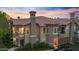 Charming condo with a balcony and attached garage featuring desert landscaping at dusk at 14250 W Wigwam Blvd # 2722, Litchfield Park, AZ 85340