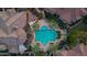 Aerial view of a resort-style pool surrounded by palm trees, lounge chairs, and elegant rooftops at 14250 W Wigwam Blvd # 2722, Litchfield Park, AZ 85340