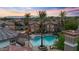 Overhead view of the pool with spa, lounge chairs, landscaping, and buildings against a colorful sky at 14250 W Wigwam Blvd # 2722, Litchfield Park, AZ 85340