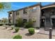 Condo building featuring desert landscaping, a private balcony, covered entry, and exterior stairs at 14815 N Fountain Hills Blvd # 101, Fountain Hills, AZ 85268