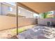 View of a shaded backyard with stone patio and tall block fence for privacy at 16021 N 30Th St # 122, Phoenix, AZ 85032