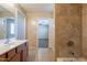 Bathroom showcasing tiled shower, bathtub and tan tile floors with a double sink vanity at 16021 N 30Th St # 122, Phoenix, AZ 85032