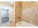 Bathroom showcasing tiled shower, bathtub and tan tile floors leading into bedroom at 16021 N 30Th St # 122, Phoenix, AZ 85032