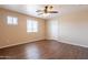 Bright bedroom with wood-look floors, neutral walls, ceiling fan and natural light from two windows at 16021 N 30Th St # 122, Phoenix, AZ 85032