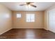 Bright bedroom with wood-look floors, neutral walls, ceiling fan and natural light from two windows at 16021 N 30Th St # 122, Phoenix, AZ 85032