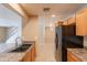Bright kitchen with wooden cabinetry, double sink, and tile floor, seamlessly connecting to living areas at 16021 N 30Th St # 122, Phoenix, AZ 85032