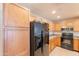 Kitchen featuring wooden cabinets, tile floor, stainless steel appliances and black refrigerator at 16021 N 30Th St # 122, Phoenix, AZ 85032