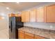 Kitchen featuring stainless steel refrigerator, wood cabinets, and tiled floor with open design at 16021 N 30Th St # 122, Phoenix, AZ 85032