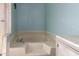 Bathroom featuring a light blue wall and a large soaking tub with chrome fixtures at 16215 N 35Th Way, Phoenix, AZ 85032