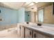 Bathroom featuring light blue walls, a large mirror, a dual sink vanity, and a soaking tub at 16215 N 35Th Way, Phoenix, AZ 85032