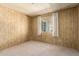 Bedroom featuring neutral carpet, wood panelled walls, and a window with coverings at 16215 N 35Th Way, Phoenix, AZ 85032