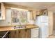 Bright kitchen featuring wood cabinets, a window, and white appliances for a cozy space at 16215 N 35Th Way, Phoenix, AZ 85032