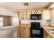 Kitchen featuring wood cabinets, black appliances, wood countertops and an adjoining living area at 16215 N 35Th Way, Phoenix, AZ 85032