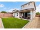 An expansive backyard with lush artificial turf, patio and exterior view of a two-story home at 16539 W Winston Dr, Goodyear, AZ 85338