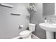 Neutral powder room featuring a pedestal sink and floating shelves at 16539 W Winston Dr, Goodyear, AZ 85338