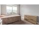 Comfortable bedroom featuring a large window, neutral carpet, and stylish dresser at 16539 W Winston Dr, Goodyear, AZ 85338
