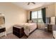 Cozy bedroom with twin bed, window views, and side table with makeup mirror at 16539 W Winston Dr, Goodyear, AZ 85338