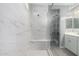 Spacious shower featuring glass door, bench, and marble tile at 16539 W Winston Dr, Goodyear, AZ 85338