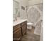 Cozy bathroom featuring wood-look floors, a classic vanity, and a decorative shower curtain at 17506 W Hadley St, Goodyear, AZ 85338