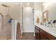 Bathroom showcasing double sinks and a shower with decorative tile at 17506 W Hadley St, Goodyear, AZ 85338