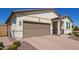 Beautiful single-level home with a brick driveway, brown garage door, and desert-friendly landscaping at 17506 W Hadley St, Goodyear, AZ 85338