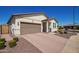 Attractive single-story home with a brown garage door, red rock landscaping, and neatly trimmed bushes at 17506 W Hadley St, Goodyear, AZ 85338