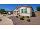 Charming single-level home featuring a neutral color palette, brick driveway, and rock landscaping at 17506 W Hadley St, Goodyear, AZ 85338