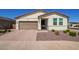 Charming single-level home featuring a neutral color palette, brick driveway, and landscaped front yard at 17506 W Hadley St, Goodyear, AZ 85338