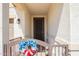 Welcoming front porch with an iron gate, featuring a charming patriotic wreath, and secure entry at 17506 W Hadley St, Goodyear, AZ 85338
