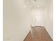 Bright hallway with wood-style flooring, leading to a white front door at 17506 W Hadley St, Goodyear, AZ 85338