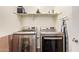 Modern laundry room equipped with front-load washer and dryer and ample shelving at 17506 W Hadley St, Goodyear, AZ 85338