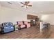 Open-concept living room flows into kitchen with stainless steel appliances and center island with bar seating at 17506 W Hadley St, Goodyear, AZ 85338