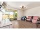 Bright living room featuring a sliding glass door leading to the backyard and wood-look tile flooring at 17506 W Hadley St, Goodyear, AZ 85338