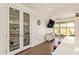 Kitchen pantry with glass doors and interior lighting, adjacent to a view of the backyard and patio at 17506 W Hadley St, Goodyear, AZ 85338