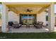 Covered patio featuring comfortable seating, ceiling fan, string lights, and sliding glass doors to the house at 17506 W Hadley St, Goodyear, AZ 85338