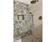 Bathroom shower featuring decorative tile, a rainfall showerhead, and a convenient built-in niche at 17506 W Hadley St, Goodyear, AZ 85338