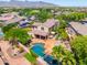 Aerial view of a backyard with a sparkling pool, mature landscaping, hot tub and an umbrella-covered patio at 20639 W Grandview Dr, Buckeye, AZ 85396