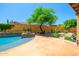 Backyard space featuring mature trees, green shrubs, decorative rock and concrete hardscape and a pool at 20639 W Grandview Dr, Buckeye, AZ 85396