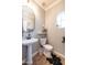 Charming powder room with a pedestal sink, decorative mirror, and a window for natural light at 20639 W Grandview Dr, Buckeye, AZ 85396